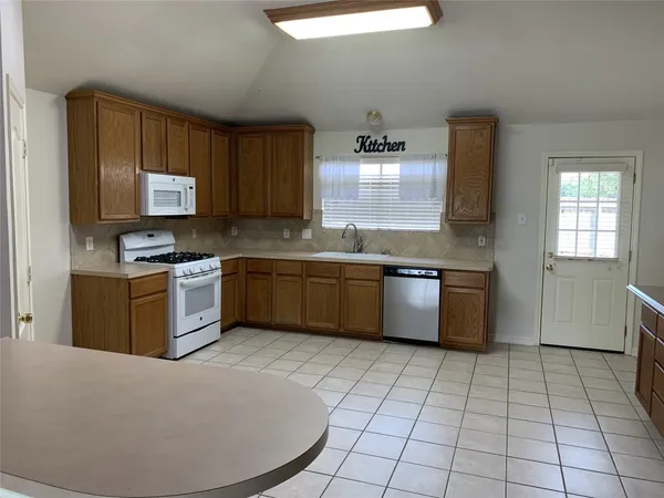 a kitchen with a sink window and refrigerator