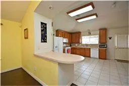 a view of a kitchen with kitchen island granite countertop a refrigerator and a sink