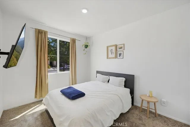 a bedroom with a bed and a flat screen tv