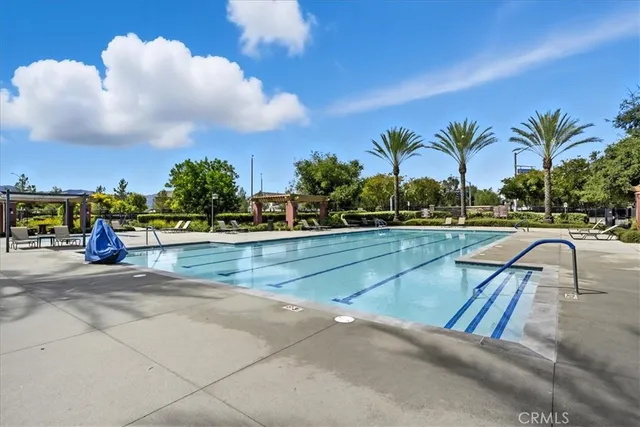 a view of pool with outdoor seating and house in the background