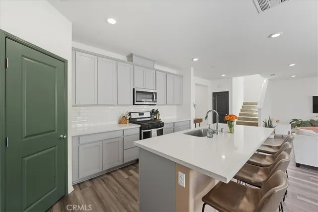 a kitchen with stainless steel appliances kitchen island a table and chairs