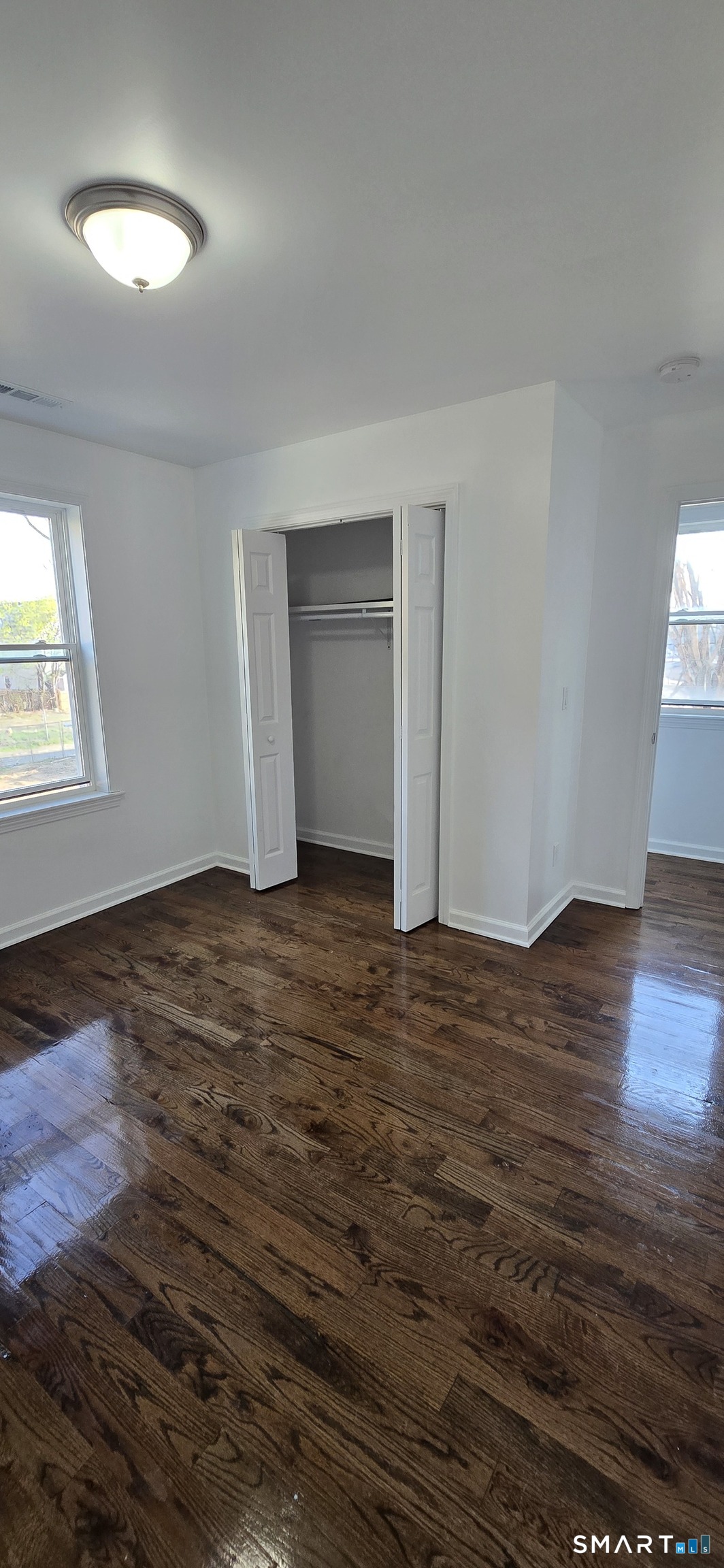 99 Johnson Street, Unit 2 Bridgeport, CT 06604 - Photo 12 of 12 an empty room with wooden floor and windows