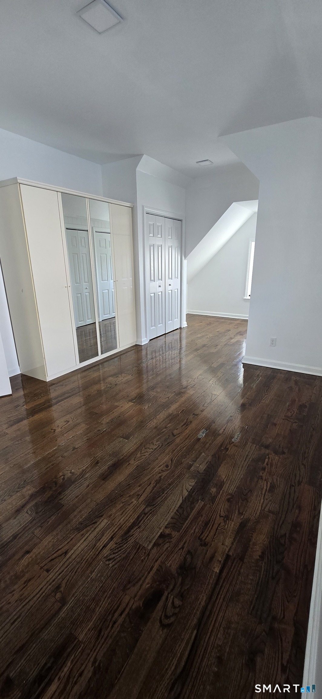 99 Johnson Street, Unit 2 Bridgeport, CT 06604 - Photo 4 of 12 a view of an empty room with wooden floor and a window