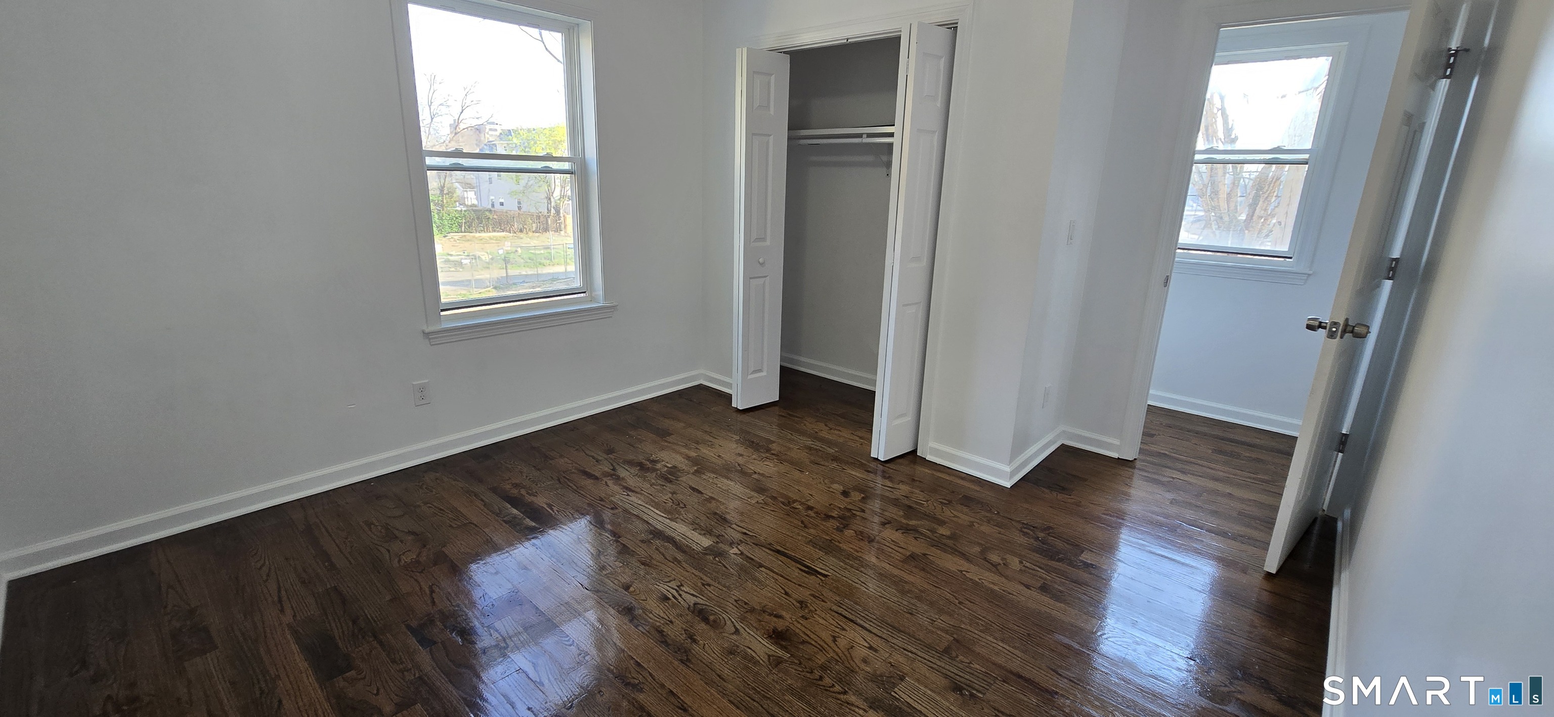 99 Johnson Street, Unit 2 Bridgeport, CT 06604 - Photo 10 of 12 an empty room with wooden floor and windows
