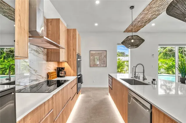 a living room with furniture kitchen view and a large window
