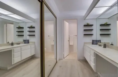 a room with a white bed furniture and a kitchen view