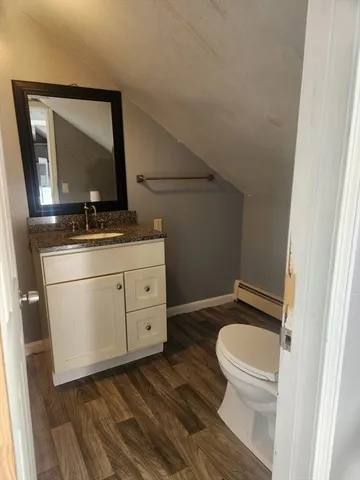 a bathroom with a toilet a sink and mirror