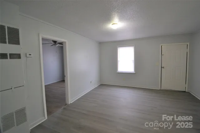 an empty room with wooden floor and a window