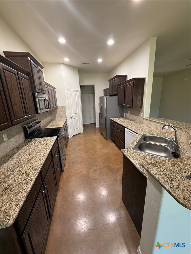 4405 Texas Rangers Drive Killeen, TX 76549 - Photo 12 of 22 a kitchen with stainless steel appliances granite countertop a sink stove and refrigerator