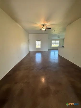 an empty room with wooden floor and windows in it