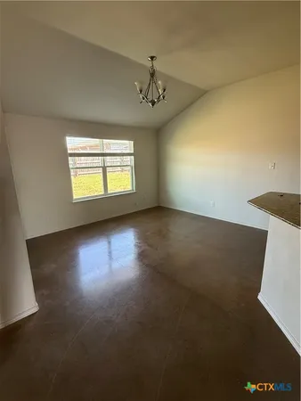 an empty room with windows and ceiling fan