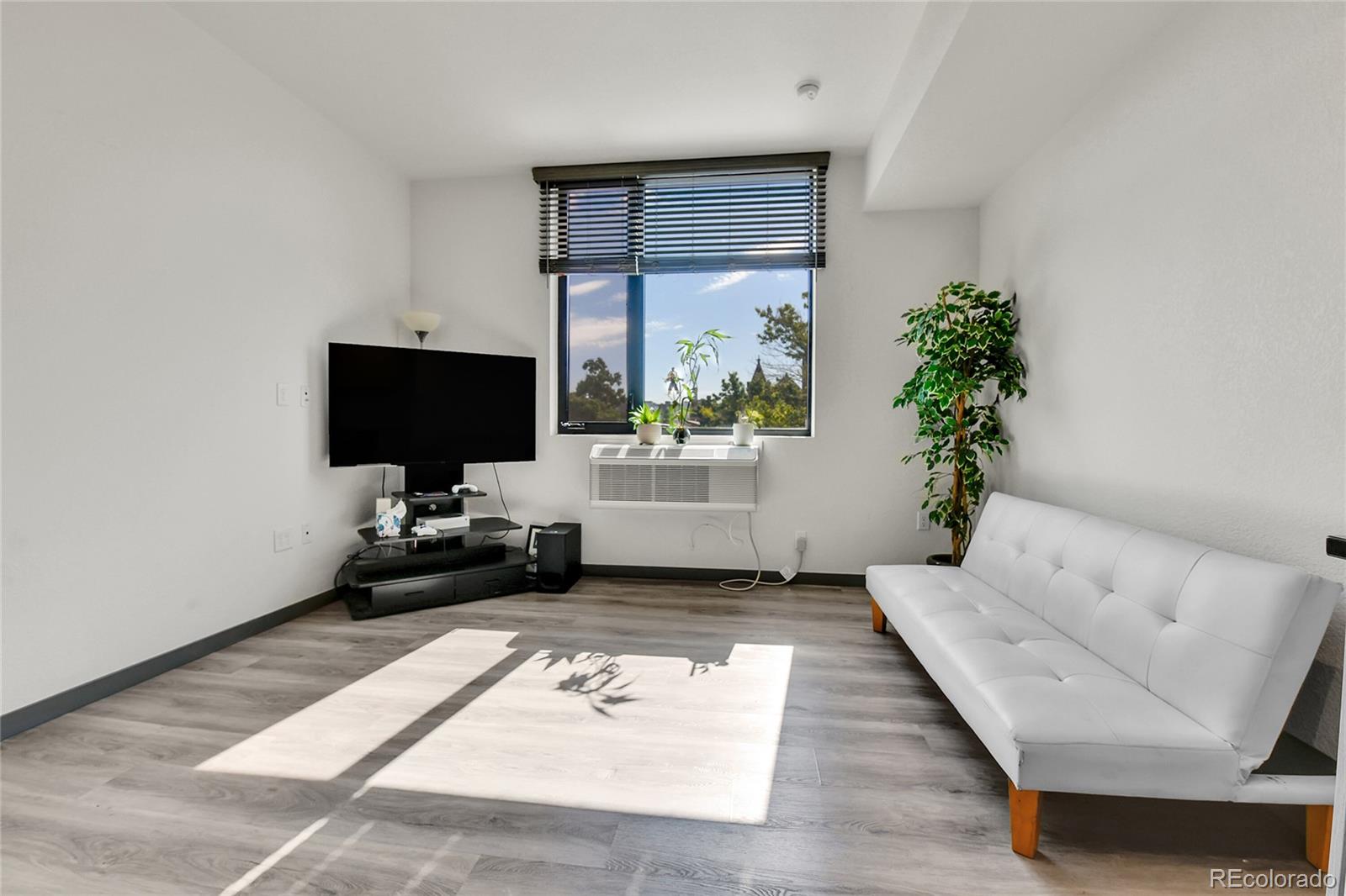 603 Inca Street, Unit 301 Denver, CO 80204 - Photo 14 of 21 a living room with furniture and a flat screen tv