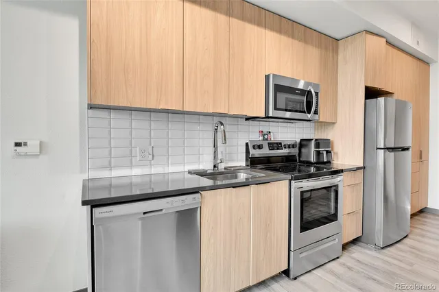 a kitchen with stainless steel appliances granite countertop a sink stove and microwave