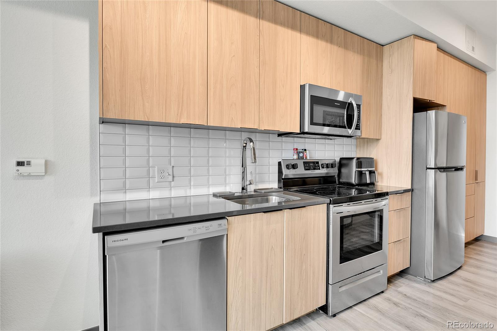 603 Inca Street, Unit 301 Denver, CO 80204 - Photo 16 of 21 a kitchen with stainless steel appliances granite countertop a sink stove and microwave