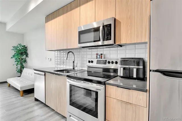 a kitchen with stainless steel appliances granite countertop a sink stove and microwave