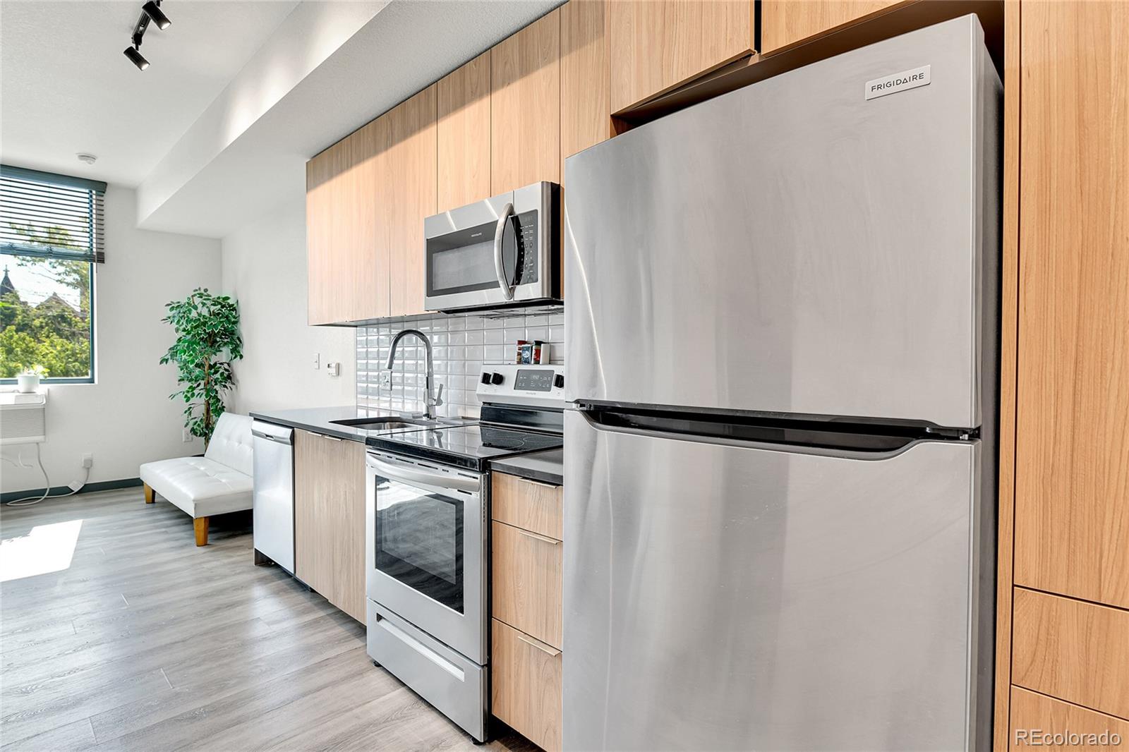 603 Inca Street, Unit 301 Denver, CO 80204 - Photo 18 of 21 a kitchen with stainless steel appliances a refrigerator sink and white cabinets