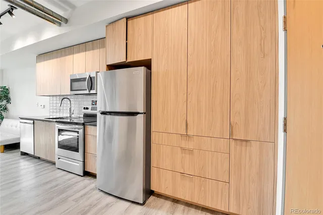 a kitchen with stainless steel appliances granite countertop a refrigerator sink and cabinets