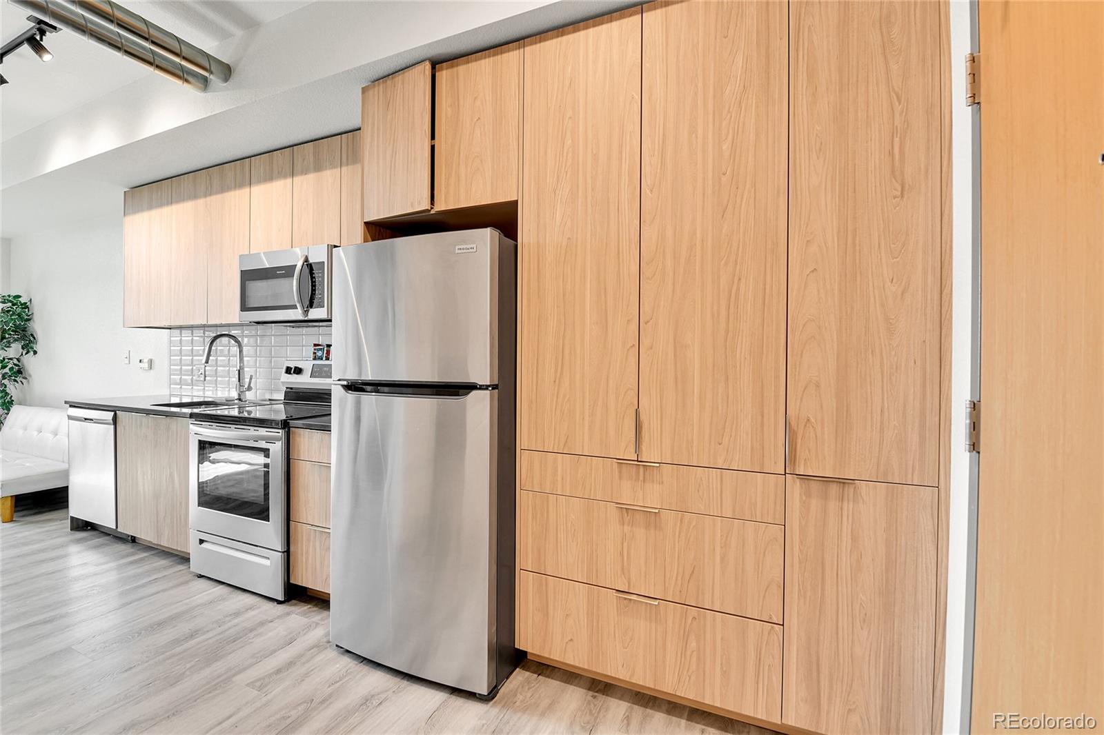 603 Inca Street, Unit 301 Denver, CO 80204 - Photo 19 of 21 a kitchen with stainless steel appliances granite countertop a refrigerator sink and cabinets