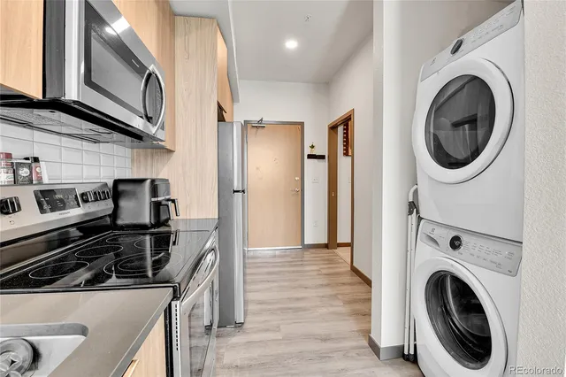 a kitchen with a stove sink and a washer dryer
