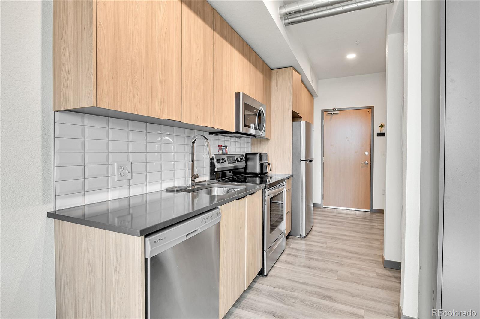 603 Inca Street, Unit 301 Denver, CO 80204 - Photo 7 of 12 a kitchen with stainless steel appliances granite countertop a sink and a stove