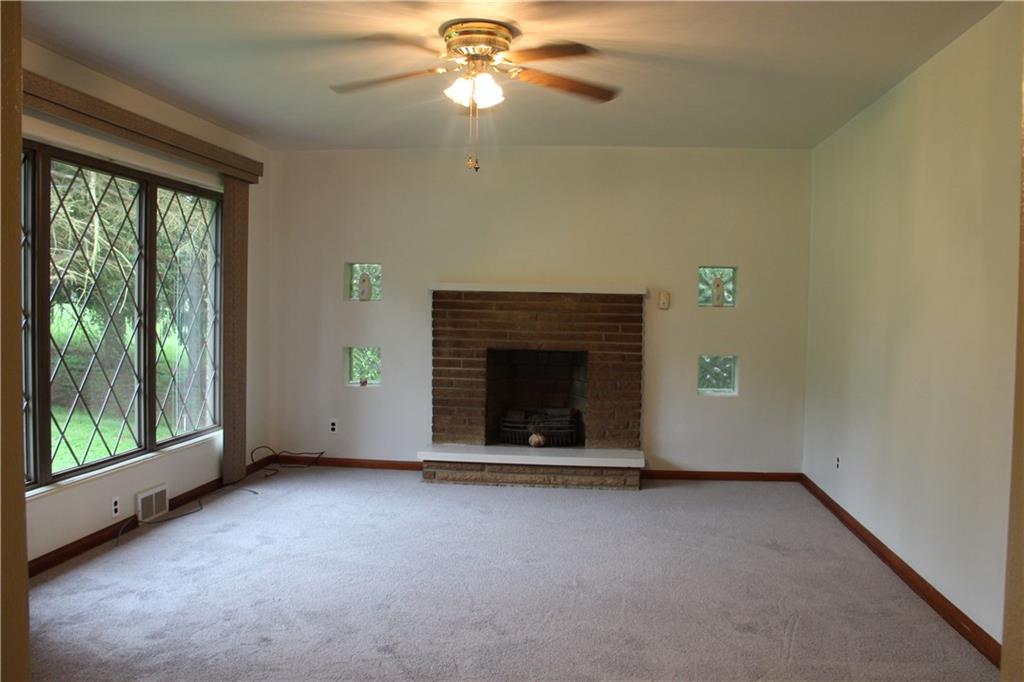 104 Compton Road Sewickley, PA 15143 - Photo 2 of 12 Open living room with large picture window, wood burning fireplace.