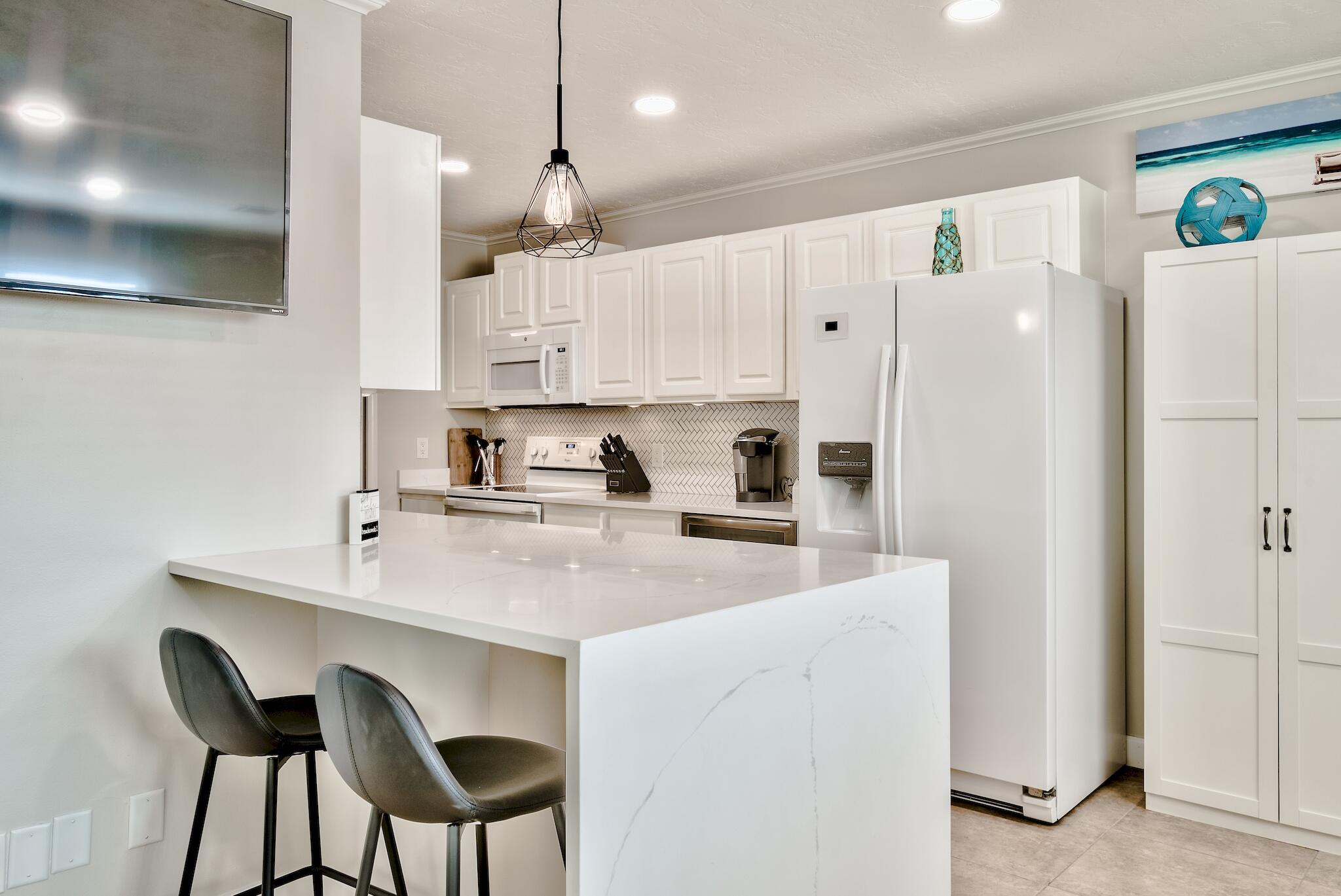 64 Cross Creek Road, Unit 11 Miramar Beach, FL 32550 - Photo 7 of 20 a kitchen with stainless steel appliances white cabinets a sink and a refrigerator