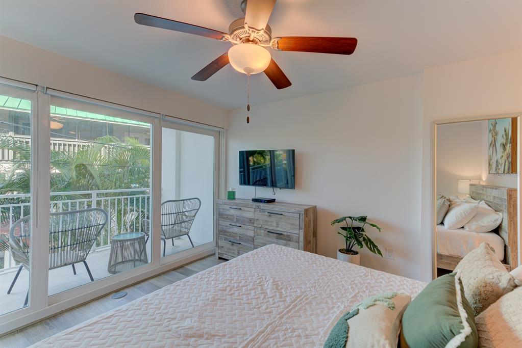 15305 1st Street East, Unit 202 Madeira Beach, FL 33708 - Photo 14 of 40 a bedroom with a bed and a large window