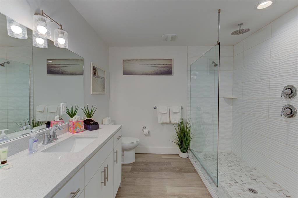 15305 1st Street East, Unit 202 Madeira Beach, FL 33708 - Photo 16 of 40 a bathroom with a sink mirror and shower