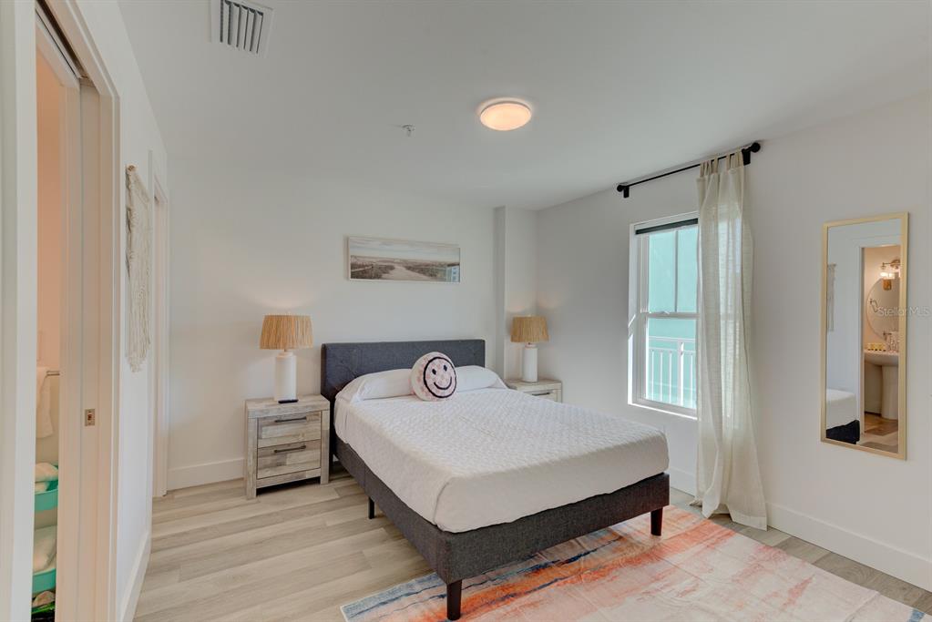 15305 1st Street East, Unit 202 Madeira Beach, FL 33708 - Photo 19 of 40 a bedroom with a bed table and a window