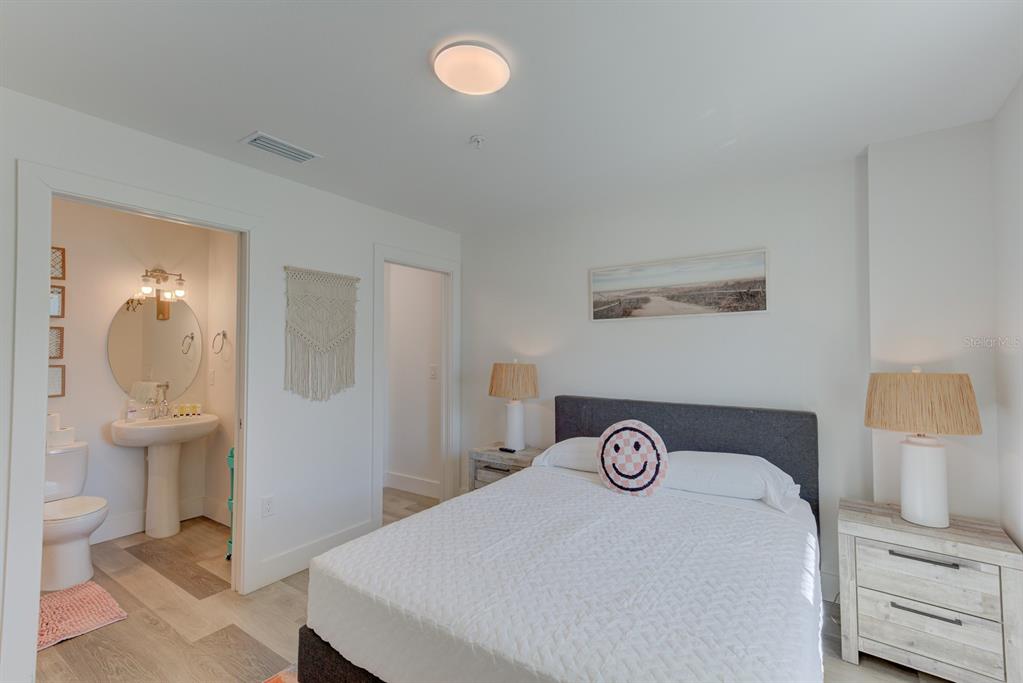 15305 1st Street East, Unit 202 Madeira Beach, FL 33708 - Photo 20 of 40 a bedroom with a bed and a table