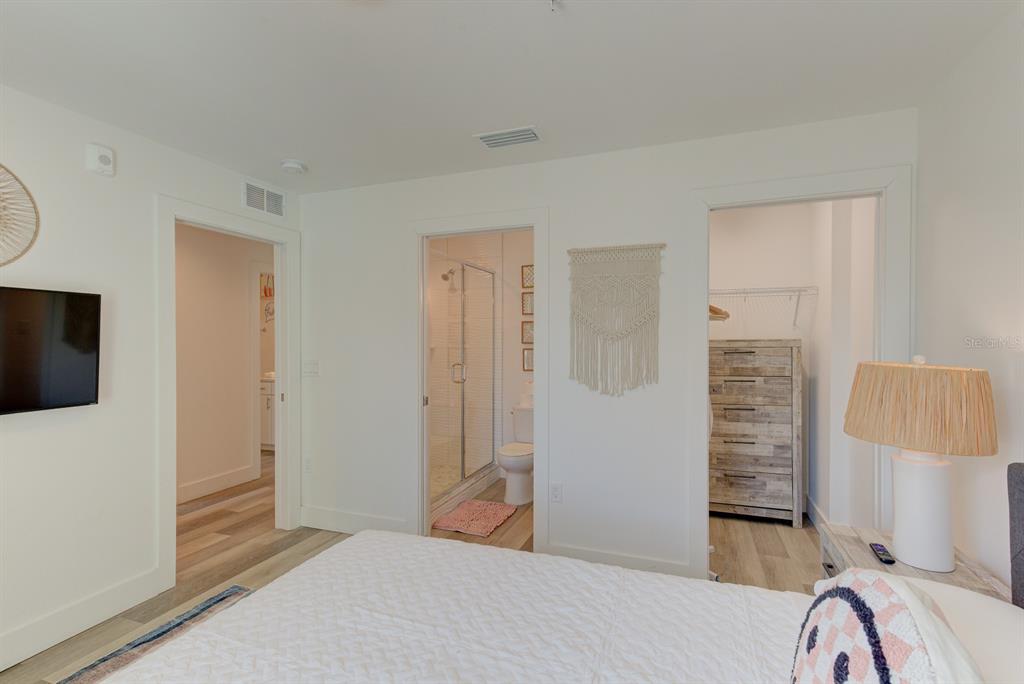 15305 1st Street East, Unit 202 Madeira Beach, FL 33708 - Photo 21 of 40 a bedroom with a bed and a flat screen tv