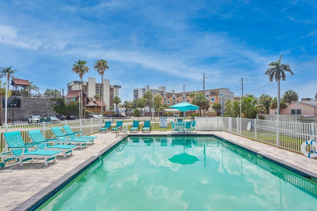 15305 1st Street East, Unit 202 Madeira Beach, FL 33708 - Photo 33 of 40 a view of a lake with a large pool and potted plants