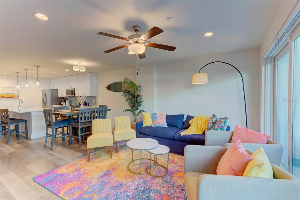 15305 1st Street East, Unit 202 Madeira Beach, FL 33708 - Photo 8 of 40 a living room with furniture kitchen view and a chandelier