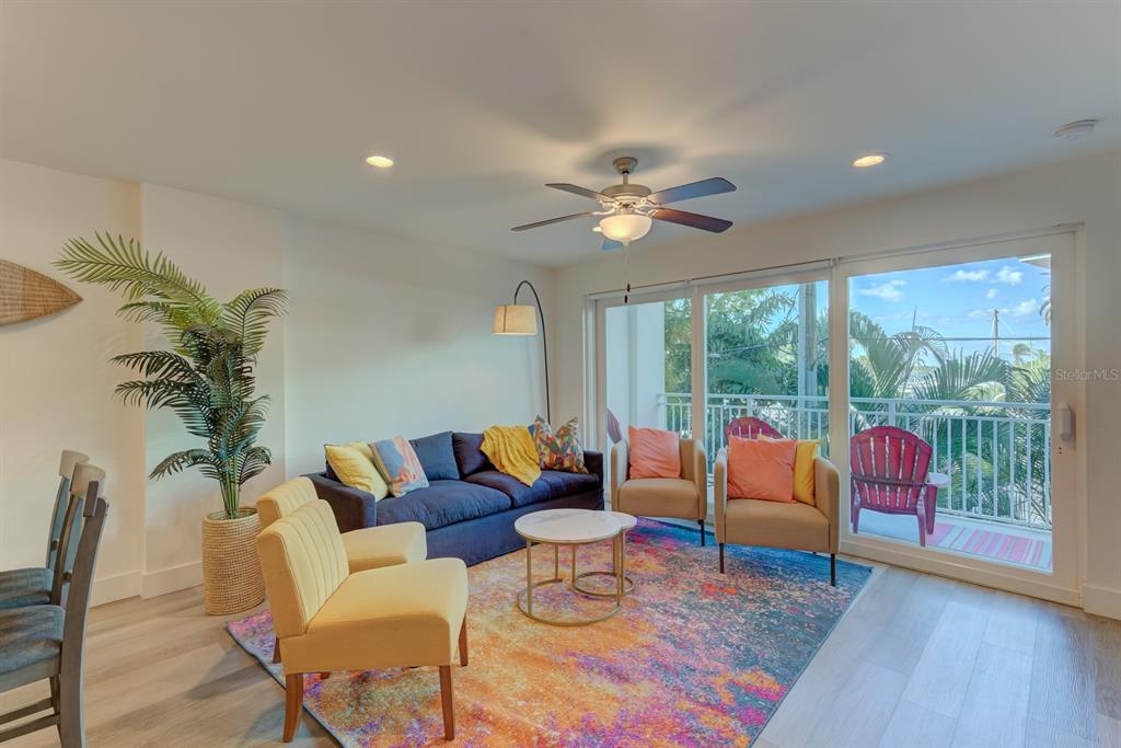 15305 1st Street East, Unit 202 Madeira Beach, FL 33708 - Photo 10 of 40 a living room with furniture and a large window with wooden floor