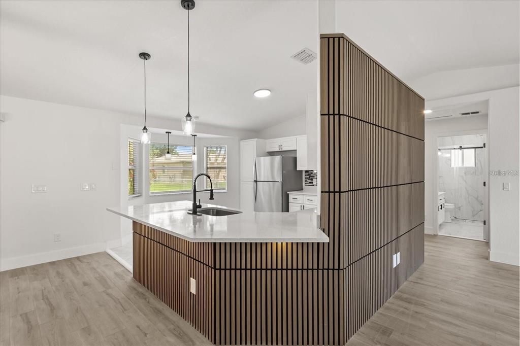 6027 Southwest 98th Street Road Ocala, FL 34476 - Photo 11 of 44 a kitchen with kitchen island a counter top space a sink and refrigerator