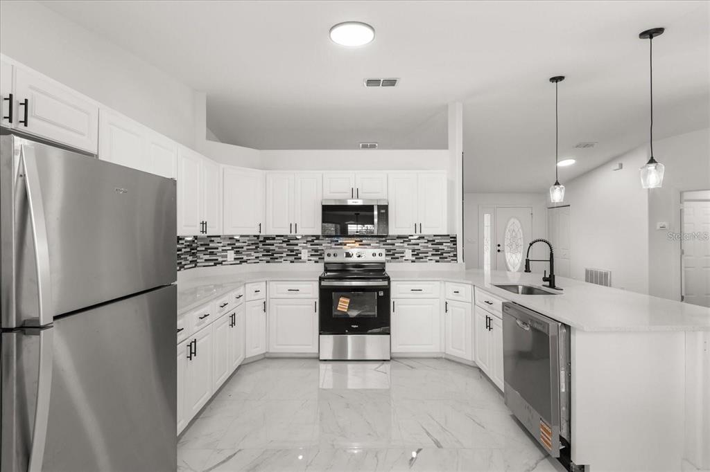 6027 Southwest 98th Street Road Ocala, FL 34476 - Photo 13 of 44 a kitchen with white cabinets and white appliances