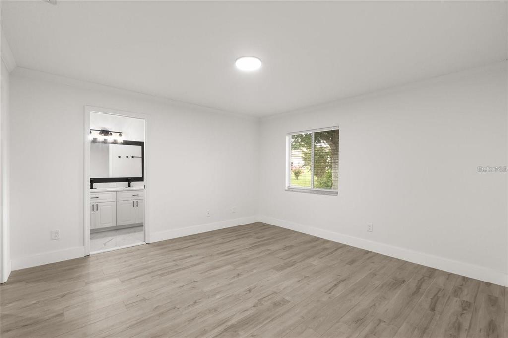 6027 Southwest 98th Street Road Ocala, FL 34476 - Photo 17 of 44 wooden floor in an empty room with a window