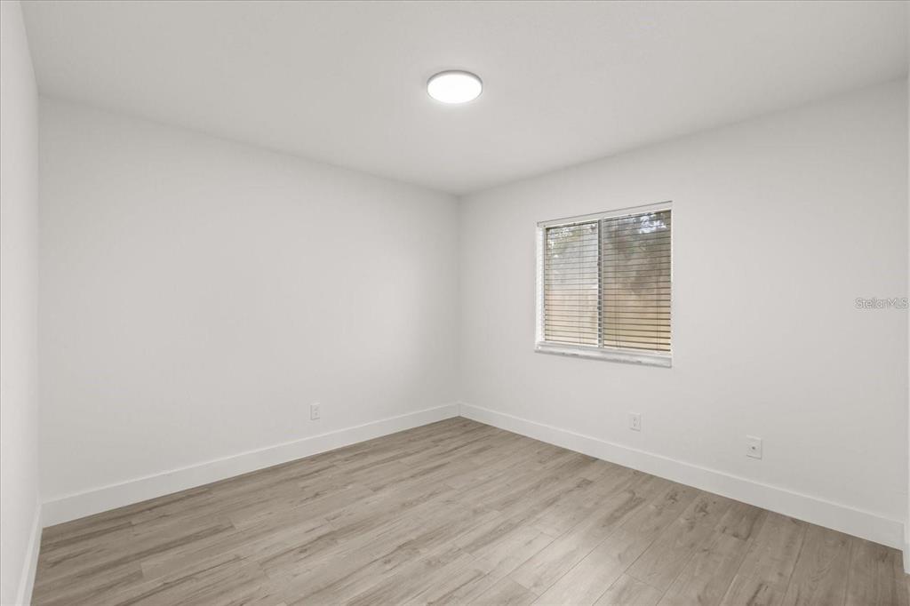 6027 Southwest 98th Street Road Ocala, FL 34476 - Photo 22 of 44 an empty room with wooden floor and windows