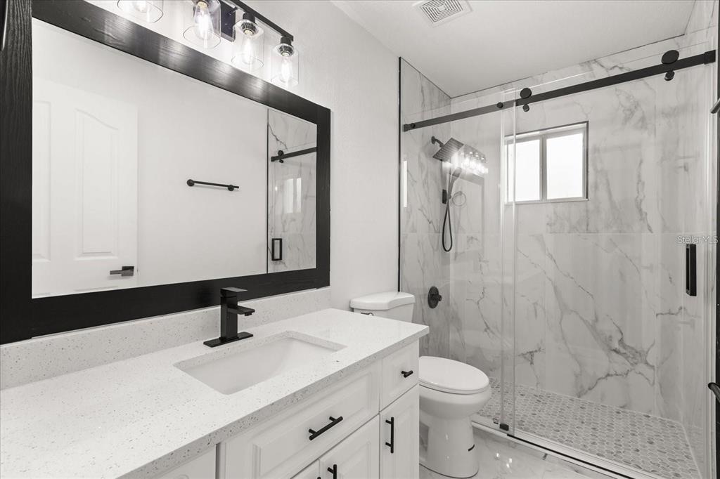 6027 Southwest 98th Street Road Ocala, FL 34476 - Photo 24 of 44 a bathroom with a sink a toilet and shower