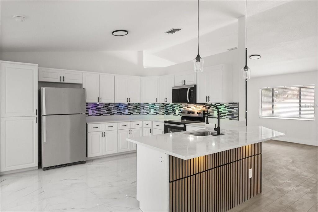 6027 Southwest 98th Street Road Ocala, FL 34476 - Photo 9 of 44 a kitchen with white cabinets and refrigerator