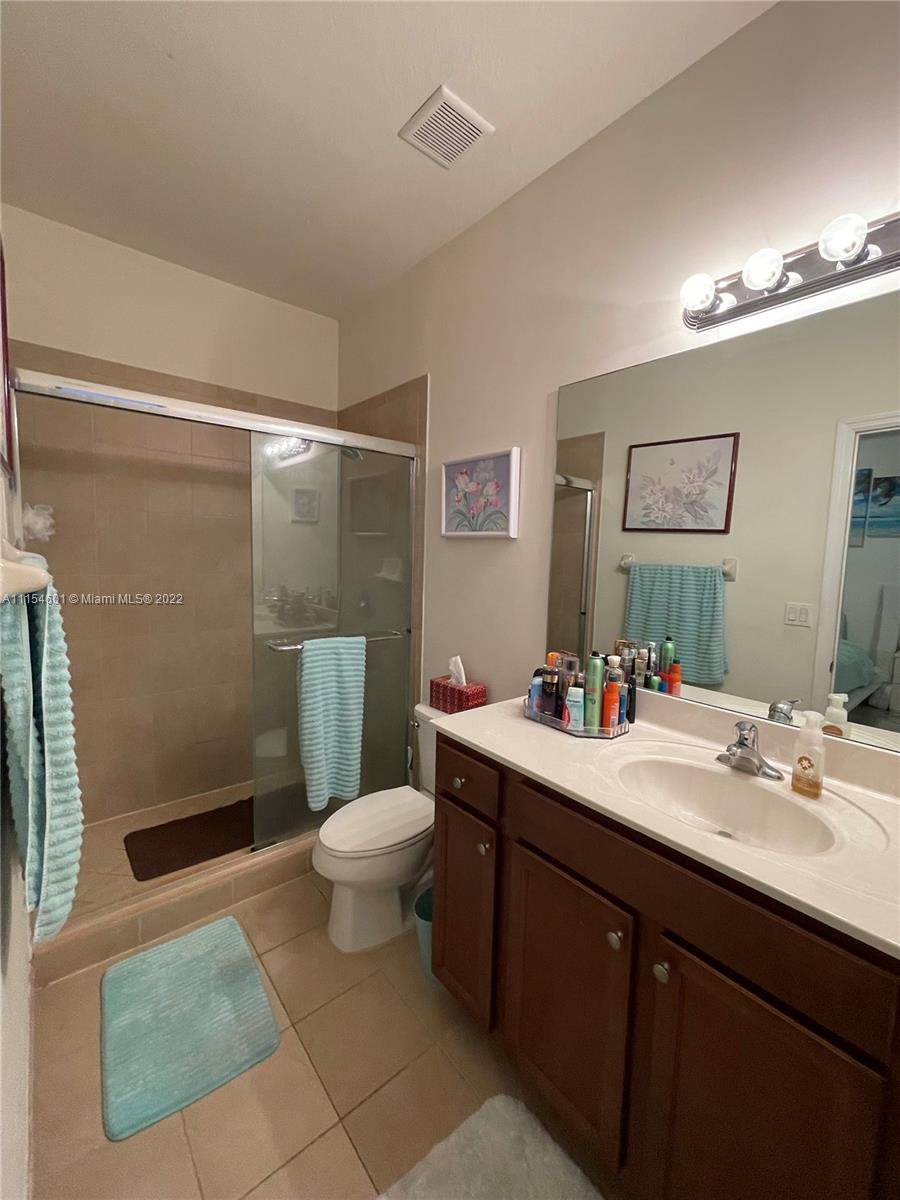 15086 Southwest 116th Street Miami, FL 33196 - Photo 11 of 19 a bathroom with a sink mirror vanity and toilet