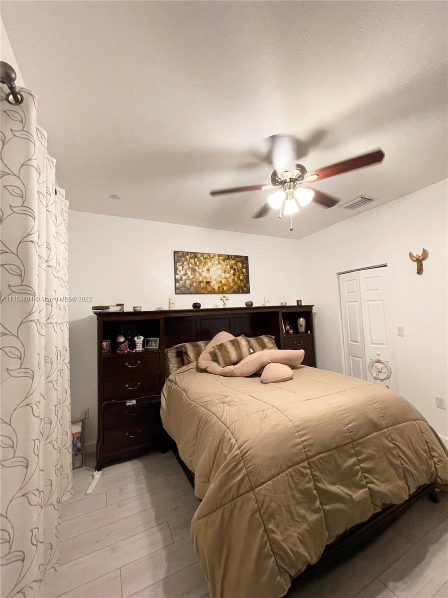 15086 Southwest 116th Street Miami, FL 33196 - Photo 14 of 19 a bedroom with a bed and a chandelier