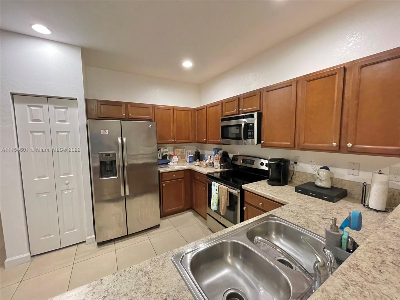 15086 Southwest 116th Street Miami, FL 33196 - Photo 2 of 19 a kitchen with stainless steel appliances granite countertop a refrigerator sink and stove