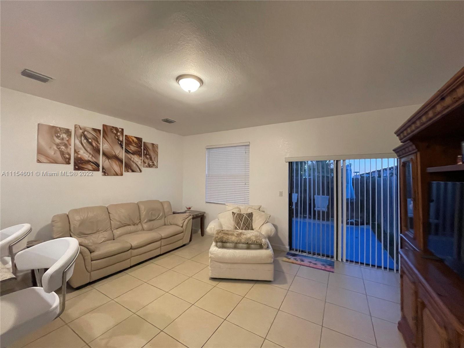 15086 Southwest 116th Street Miami, FL 33196 - Photo 6 of 19 a living room with furniture and a flat screen tv