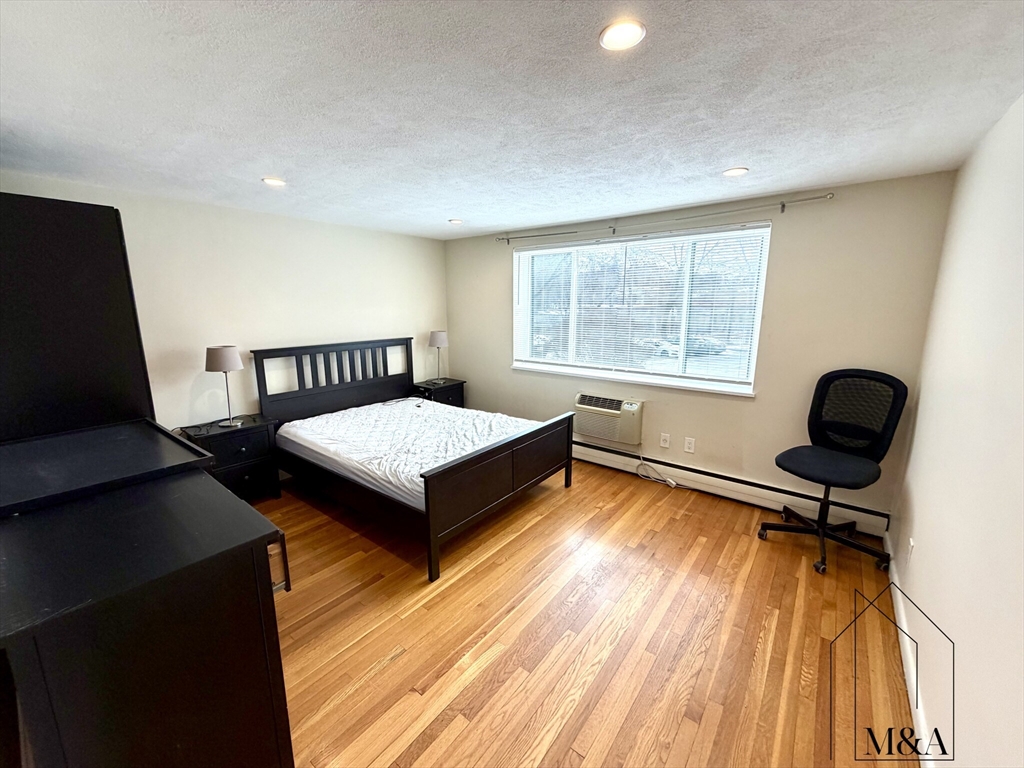 197 Kent Street, Unit 15 Brookline, MA 02446 - Photo 5 of 10 a bedroom with a bed and a desk