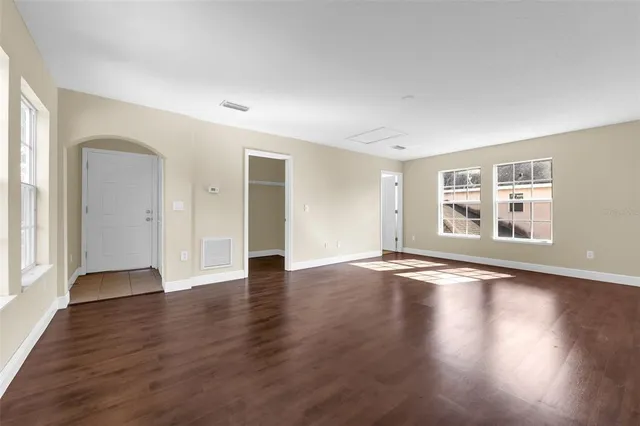 a green field with lots of trees in the background