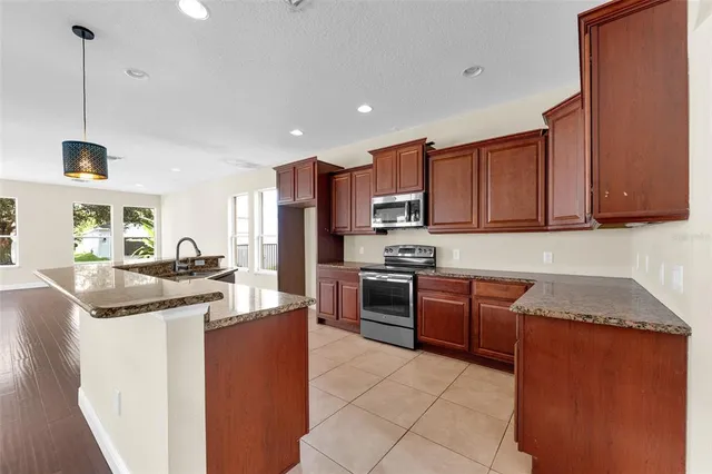 a kitchen with stainless steel appliances granite countertop a sink stove and refrigerator