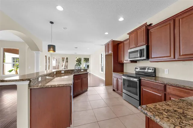 a kitchen with granite countertop a sink stove and cabinets