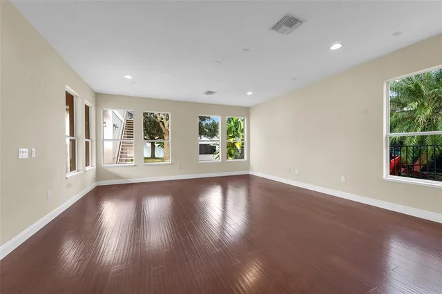 a view of a kitchen with a fridge and wooden floor