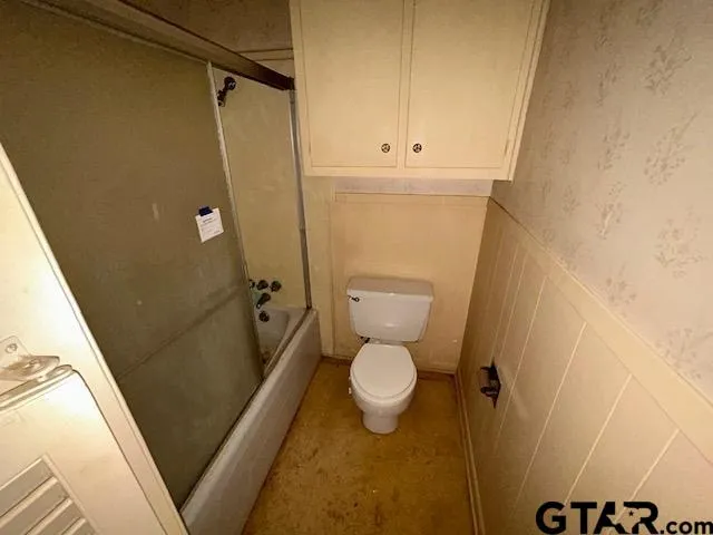 a bathroom with a granite countertop toilet and a shower